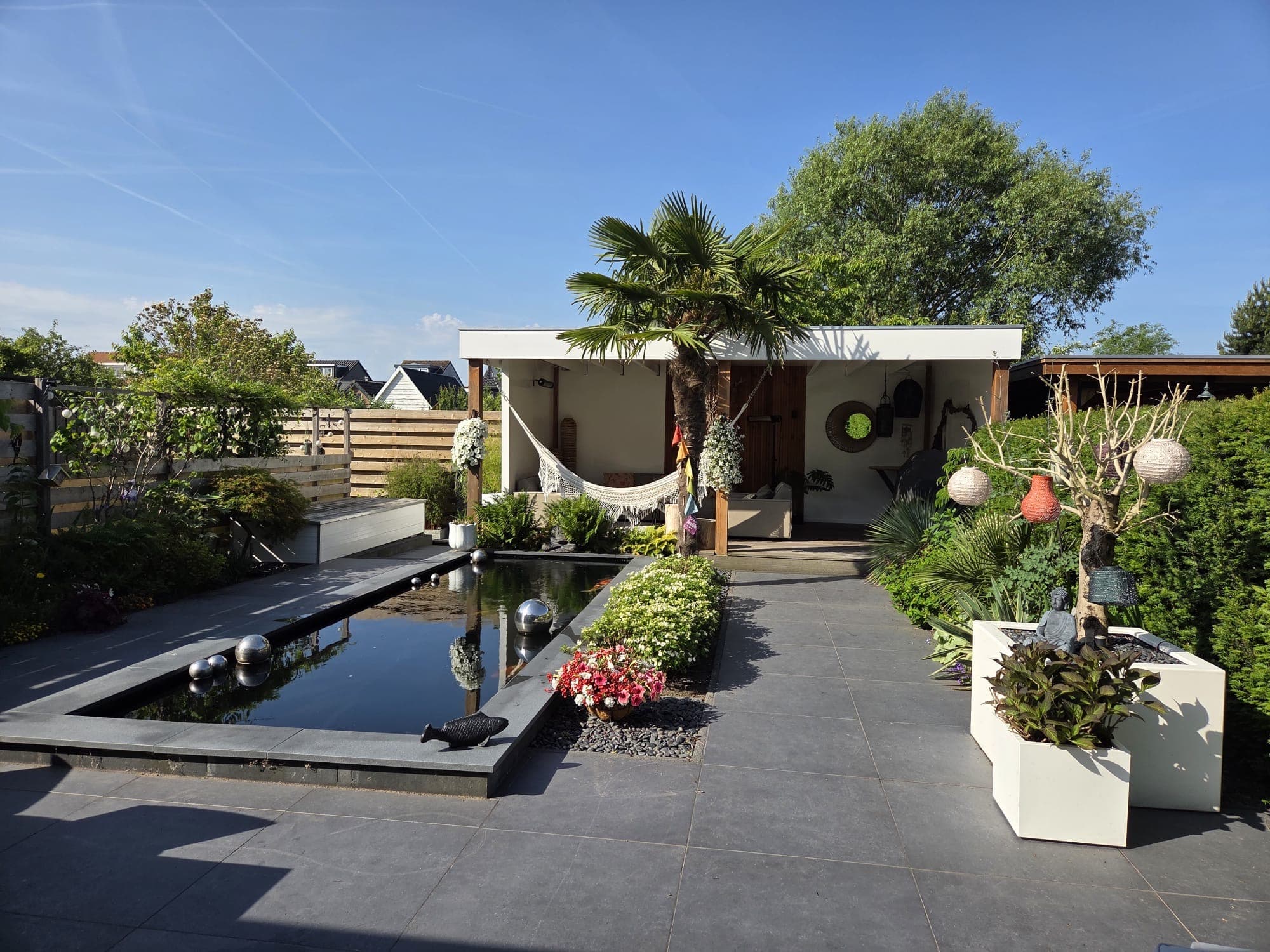 Tuin bij daglicht met vijver en terras